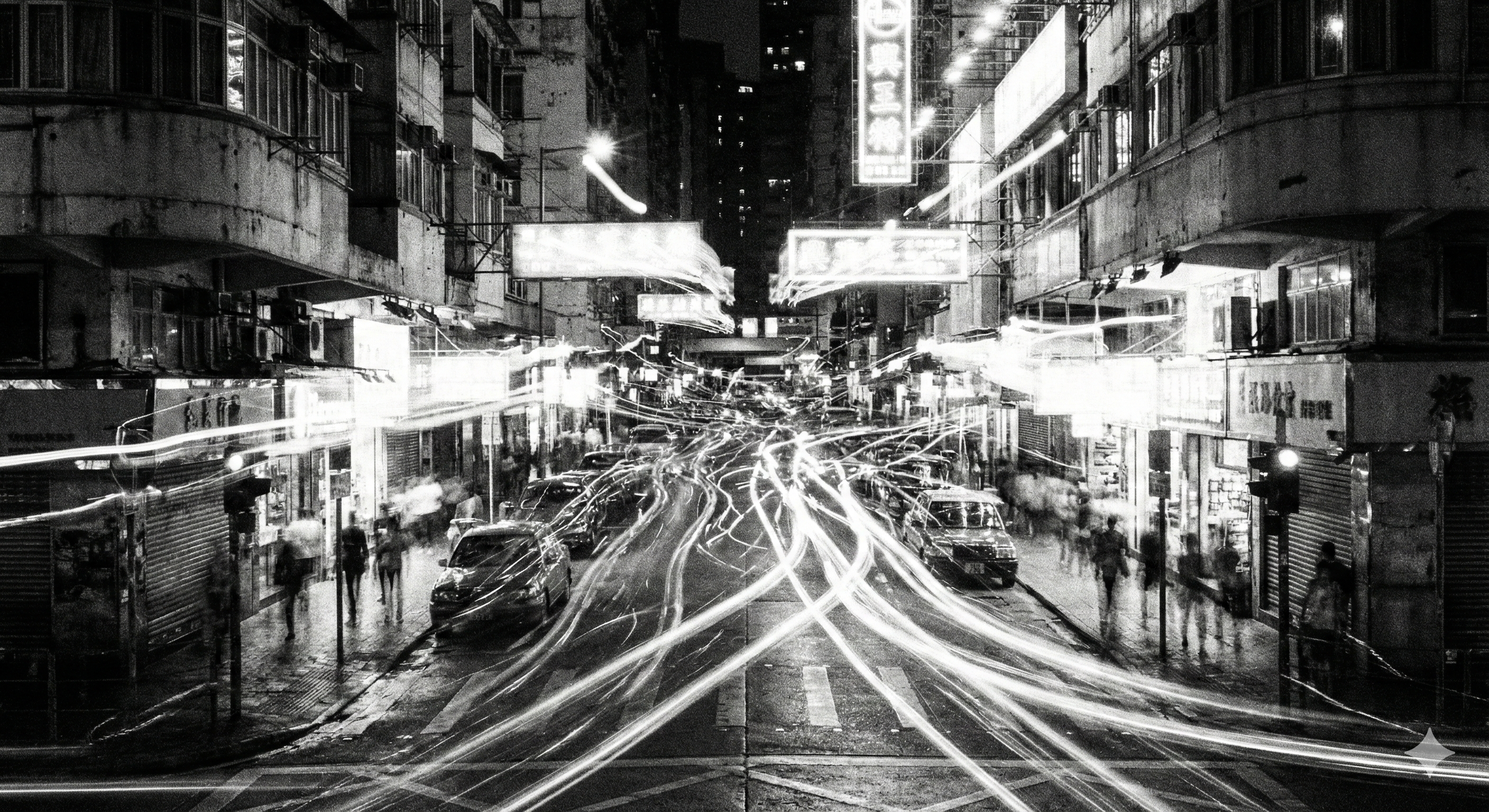 Black and white long exposure of a crowded city street at night, featuring chaotic light trails and blurred figures symbolizing urban noise.